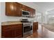 Modern kitchen with stainless steel appliances, wood cabinetry, and granite countertops at 4217 Box Canyon Falls Ave, North Las Vegas, NV 89085