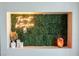 Decorative accent wall with greenery, neon sign, candles, and a Himalayan salt lamp at 4381 W Flamingo Rd # 1504, Las Vegas, NV 89103