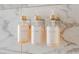 Close-up of mounted Shampoo, Conditioner, and Body Wash dispensers against decorative marble tile at 4381 W Flamingo Rd # 1504, Las Vegas, NV 89103