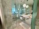 Modern bathroom with marble tile, dual sinks, and a glass-enclosed shower and bath at 4381 W Flamingo Rd # 1504, Las Vegas, NV 89103