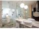 Well-lit bathroom featuring dual sinks, a glass-enclosed shower, and modern fixtures with a clean design at 4381 W Flamingo Rd # 1504, Las Vegas, NV 89103