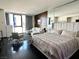 Modern bedroom featuring floor-to-ceiling windows, dark wood floors and a comfortable sitting area at 4381 W Flamingo Rd # 1504, Las Vegas, NV 89103