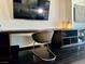 Close-up of the bedroom desk and modern chair with dark wood flooring at 4381 W Flamingo Rd # 1504, Las Vegas, NV 89103