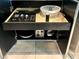 A kitchen cabinet with open storage, showcasing a toaster, dishware and utensils at 4381 W Flamingo Rd # 1504, Las Vegas, NV 89103