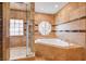 Bathroom showcasing a soaking tub with tile surround and shower with glass door at 4775 N Grand Canyon Dr, Las Vegas, NV 89129