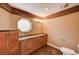 Bathroom with wood cabinets, granite counters, and decorative lighting at 4775 N Grand Canyon Dr, Las Vegas, NV 89129