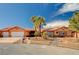Desert home featuring a three car garage, terra cotta roof, mature palms and manicured xeriscaped yard at 4775 N Grand Canyon Dr, Las Vegas, NV 89129