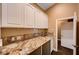 Convenient laundry room with granite counters, white cabinets, and a sink for easy cleanup at 4775 N Grand Canyon Dr, Las Vegas, NV 89129