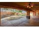 Inviting covered patio featuring ceiling fans and stone-accented columns, overlooking the beautifully landscaped backyard at 4775 N Grand Canyon Dr, Las Vegas, NV 89129