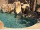 Backyard pool area featuring a rock waterfall feature and perimeter palm trees at 4775 N Grand Canyon Dr, Las Vegas, NV 89129
