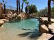Backyard pool area featuring a rock waterfall feature and perimeter palm trees at 4775 N Grand Canyon Dr, Las Vegas, NV 89129