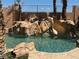 Backyard pool area featuring a rock waterfall feature and perimeter palm trees at 4775 N Grand Canyon Dr, Las Vegas, NV 89129