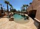Backyard pool area featuring a rock waterfall feature and perimeter palm trees at 4775 N Grand Canyon Dr, Las Vegas, NV 89129