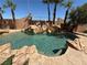 Backyard pool area featuring a rock waterfall feature and perimeter palm trees at 4775 N Grand Canyon Dr, Las Vegas, NV 89129