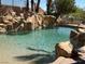 Backyard pool area featuring a rock waterfall feature and perimeter palm trees at 4775 N Grand Canyon Dr, Las Vegas, NV 89129