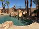 Backyard pool area featuring a rock waterfall feature and perimeter palm trees at 4775 N Grand Canyon Dr, Las Vegas, NV 89129