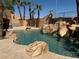Backyard pool area featuring a rock waterfall feature and perimeter palm trees at 4775 N Grand Canyon Dr, Las Vegas, NV 89129