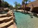 Backyard pool area featuring a rock waterfall feature and perimeter palm trees at 4775 N Grand Canyon Dr, Las Vegas, NV 89129