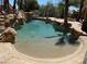 Beautiful pool with a sandy bottom, rock accents and palm tree shadows at 4775 N Grand Canyon Dr, Las Vegas, NV 89129