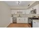 Modern kitchen with stainless steel appliances, quartz countertops, and white cabinetry at 4804 Apawana Ln, Las Vegas, NV 89108