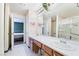 Bathroom with dual sinks, vanity, and mirror, plus a shower and toilet in separate rooms at 502 Cosmic Star Pl, Henderson, NV 89052
