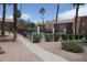 View of condo complex with pool, palm trees and gravel landscaping at 5220 Indian River Dr # 277, Las Vegas, NV 89103