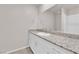 Bathroom vanity features a stone countertop, white cabinets, and a wide mirror at 5252 Sunstone Mesa Dr, Las Vegas, NV 89166