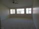 Spacious room with a ceiling fan and multiple windows offering ample natural light at 5488 Apron Ct, Las Vegas, NV 89122