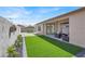 Beautiful backyard featuring artificial grass, patio seating, and updated landscaping at 5600 Blue Peak Ave, Las Vegas, NV 89131