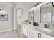 Bright bathroom with double sink vanity, black hardware, arched doorway, and modern fixtures at 5600 Blue Peak Ave, Las Vegas, NV 89131