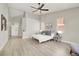 Bright main bedroom featuring light wood flooring, ceiling fan, and natural light from large windows at 5600 Blue Peak Ave, Las Vegas, NV 89131