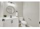 A well lit powder room with a modern vanity and a round mirror above the sink at 5600 Blue Peak Ave, Las Vegas, NV 89131