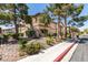 Condominium exterior featuring desert landscaping, mature trees, and walkway access at 5751 E Hacienda Ave # 105, Las Vegas, NV 89122