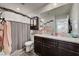 Bathroom with granite countertop, decorative mirror and wood laminate flooring at 6231 Portland Treaty Ave, Las Vegas, NV 89122