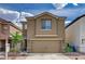 Two-story home with a two-car garage, desert landscaping, and a well-maintained lawn at 6231 Portland Treaty Ave, Las Vegas, NV 89122
