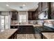 Gourmet kitchen featuring dark cabinetry, granite countertops, stainless steel appliances, and tile backsplash at 6231 Portland Treaty Ave, Las Vegas, NV 89122
