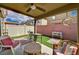Relaxing covered patio with seating area, artificial grass, and privacy fence at 6231 Portland Treaty Ave, Las Vegas, NV 89122