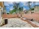 A fenced backyard shows the patio and a stone area alongside lush neighborhood landscaping at 6549 Butterfly Sky St, North Las Vegas, NV 89084