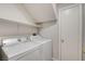Functional laundry room with a washer, dryer, and storage shelving at 6549 Butterfly Sky St, North Las Vegas, NV 89084