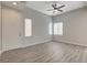 Bright living room with wood-style flooring, ceiling fan, and natural light from the windows at 6549 Butterfly Sky St, North Las Vegas, NV 89084