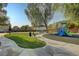 Community playground area with lush greenery, play equipment, and benches for relaxation at 6549 Butterfly Sky St, North Las Vegas, NV 89084