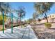 Community playground and monkey bars surrounded by mature trees, landscaping, and homes at 6549 Butterfly Sky St, North Las Vegas, NV 89084