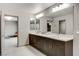 Bathroom showcasing a double vanity with dark wood cabinets, marble countertop, and large mirror at 6618 Tangled Vines Ave, Las Vegas, NV 89139