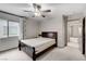 Bedroom with a dark headboard, ceiling fan, and lots of natural light from a large window at 6618 Tangled Vines Ave, Las Vegas, NV 89139