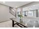 Bright foyer showcasing view into living room, recessed lighting, and stairs with dark wood railing at 6618 Tangled Vines Ave, Las Vegas, NV 89139