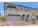 Inviting two-story home with stone accents, upper balcony, two-car garage, and desert-style landscaping at 6618 Tangled Vines Ave, Las Vegas, NV 89139