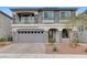 Two-story home with a two-car garage, balcony, stone accents, and well-maintained landscaping at 6618 Tangled Vines Ave, Las Vegas, NV 89139