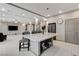 Open-concept kitchen featuring an island with seating, bright recessed lighting and stainless appliances at 6618 Tangled Vines Ave, Las Vegas, NV 89139