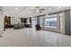 Spacious open-concept living area with coffered ceiling, bright tile flooring, and a sliding glass door at 6618 Tangled Vines Ave, Las Vegas, NV 89139