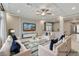 Brightly lit living room with ample seating, coffered ceiling, and a large television at 6618 Tangled Vines Ave, Las Vegas, NV 89139
